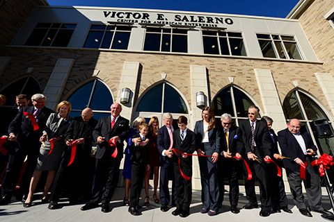 A group of people cutting a ribbon at the entrance of the Salerno Center.