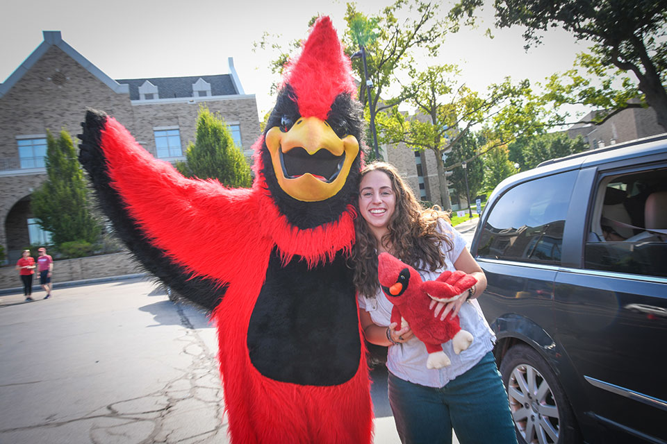 Cardinal poses with a member of the Class of 2026 (and a mini cardinal)!
