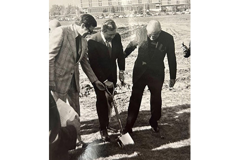 A group of people standing with a shovel at the groundbreaking of the athletic center.