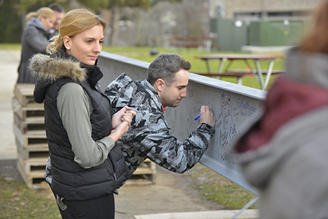 Fisher community signing the chapel beam during construction.