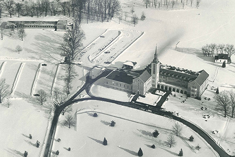 Aerial view of Kearney Hall and undeveloped campus field in winter.