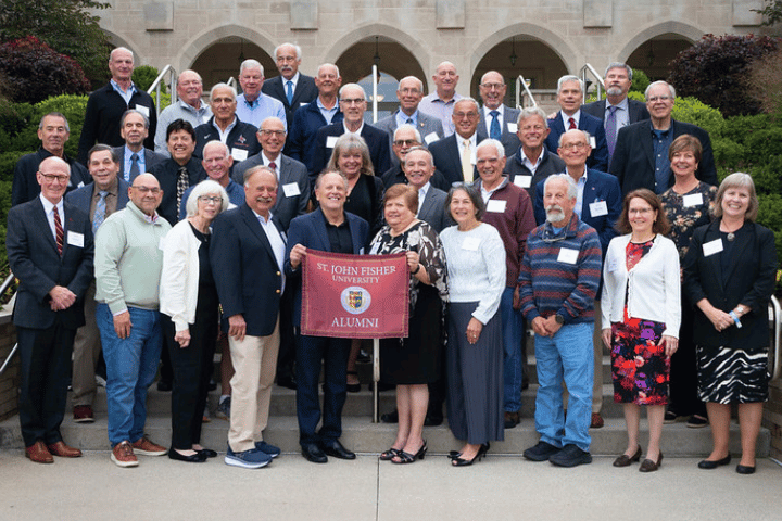 Group photo of alumni holding a Fisher Alumni signs