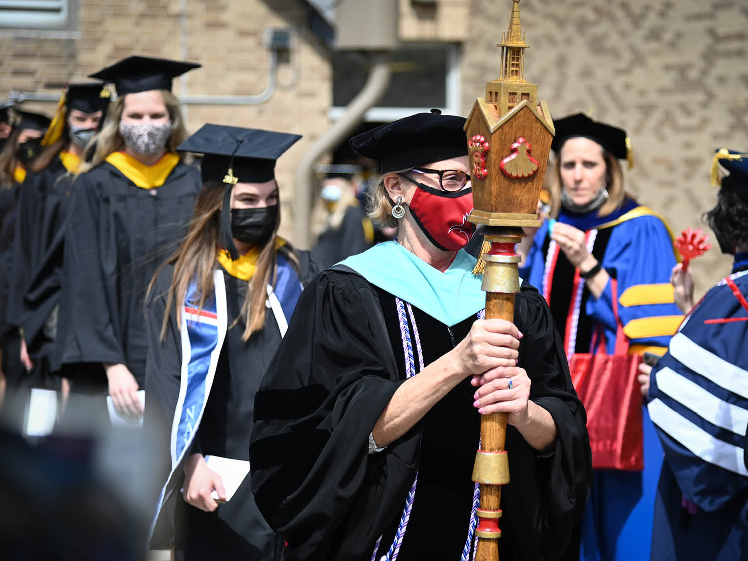 The faculty mace-bearer leading graduates in the Commencement procession