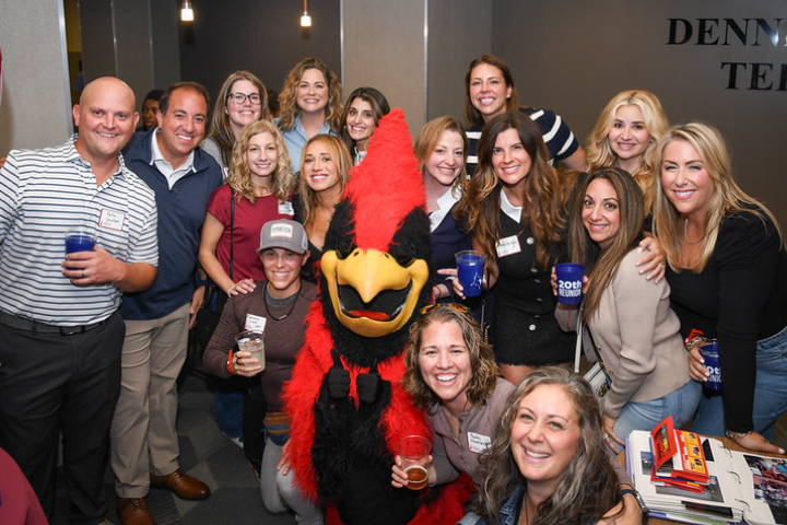 Alumni gathering for a 20th reunion photo with Beaks the mascot