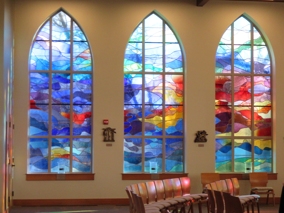Three stained glass windows inside a chapel
