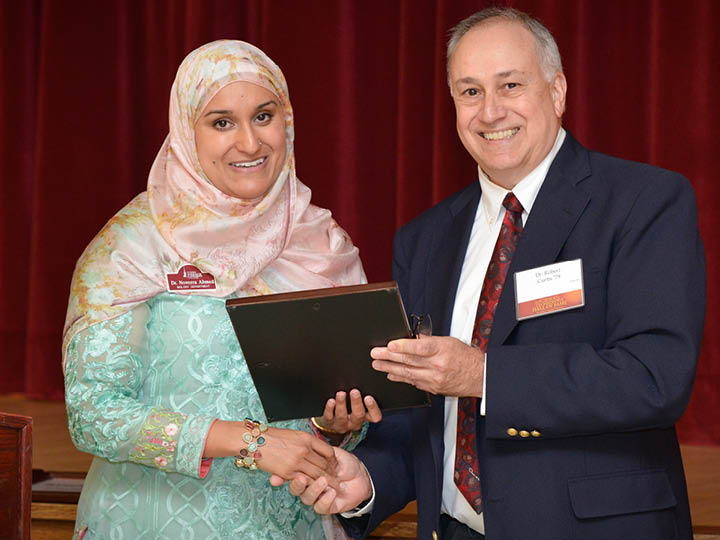Dr. Bob Curtis ’78 presents Dr. Noveera Ahmed ’99 with a science Rising Star Award