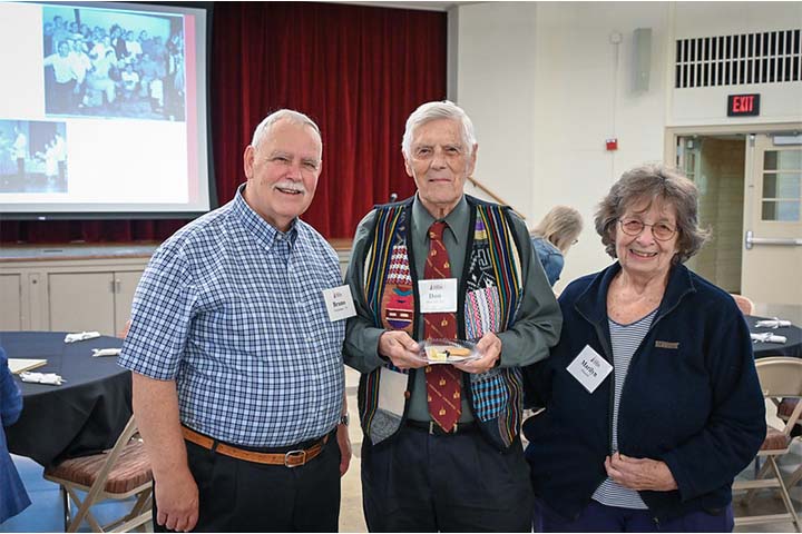 Three friends standing together at a luncheon