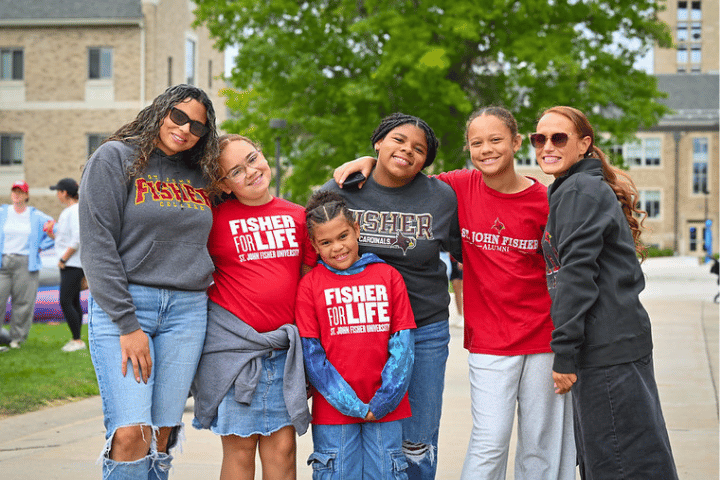 Group of adults and children all wearing Fisher shirts at the Fisher Carnival