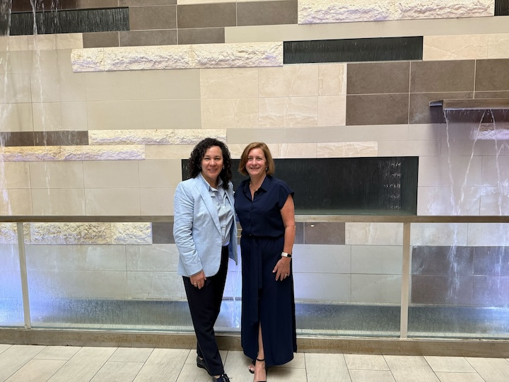 Holly and Jane standing together in a conference center