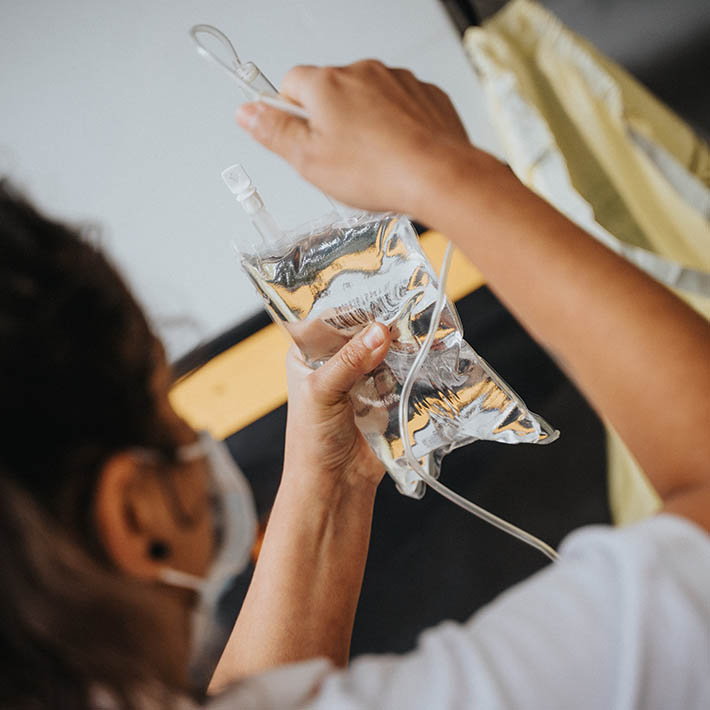 A nurse holding an IV bag.