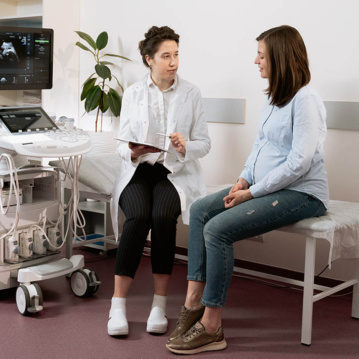 A nurse talking to a patient in a medical setting.
