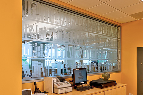 Window with privacy film decorated with books at the Library Services desk.