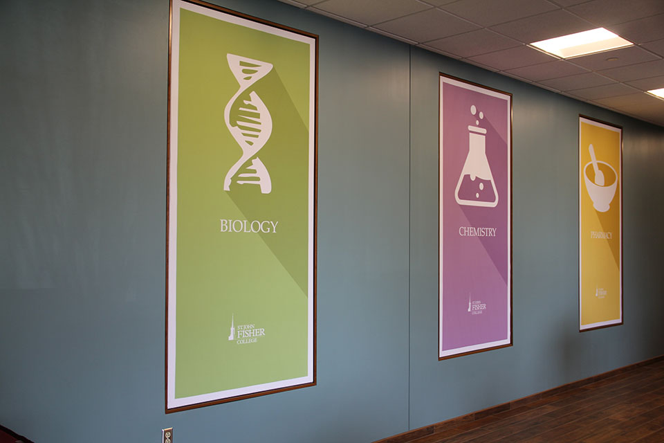 Banners on a wall in the Integrated Science and Health Sciences Building showcases the many disciplines students can explore at Fisher.