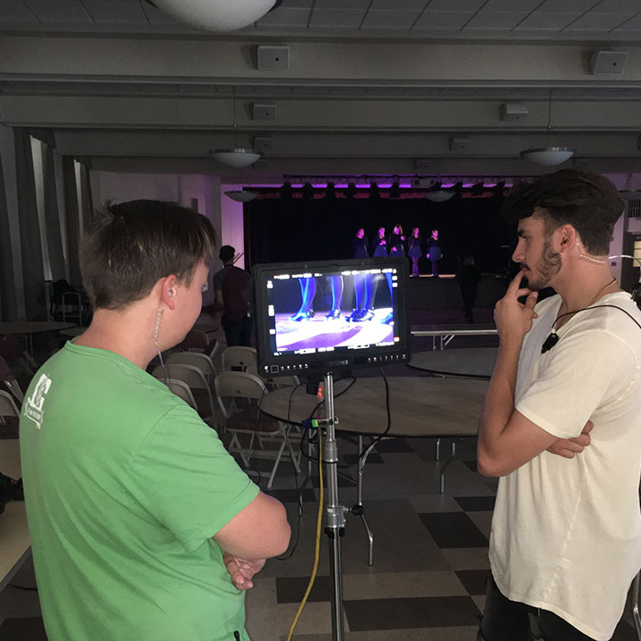 Thomas Clark and Patrick Kravitz, Fisher students who served as PAs on set, help during a scene with the Irish Dance Club.