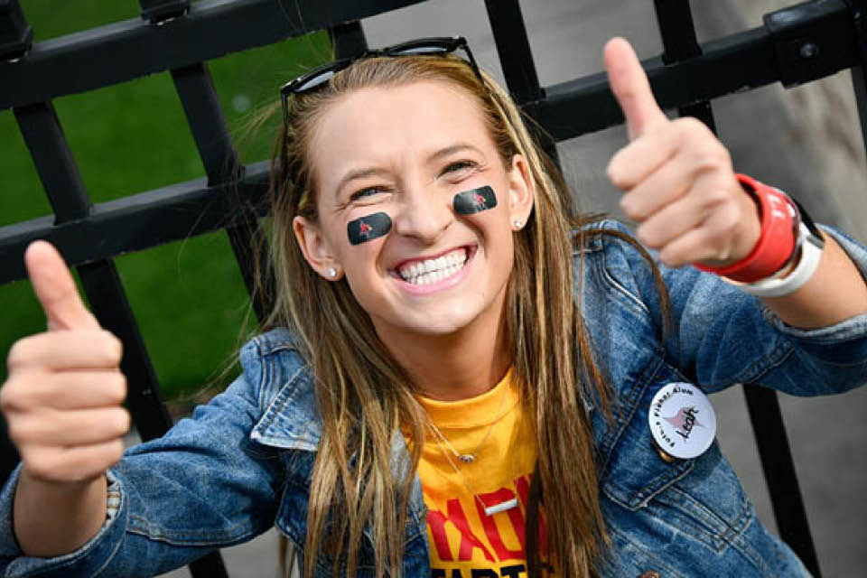 Fisher student smiling and giving thumbs up to camera