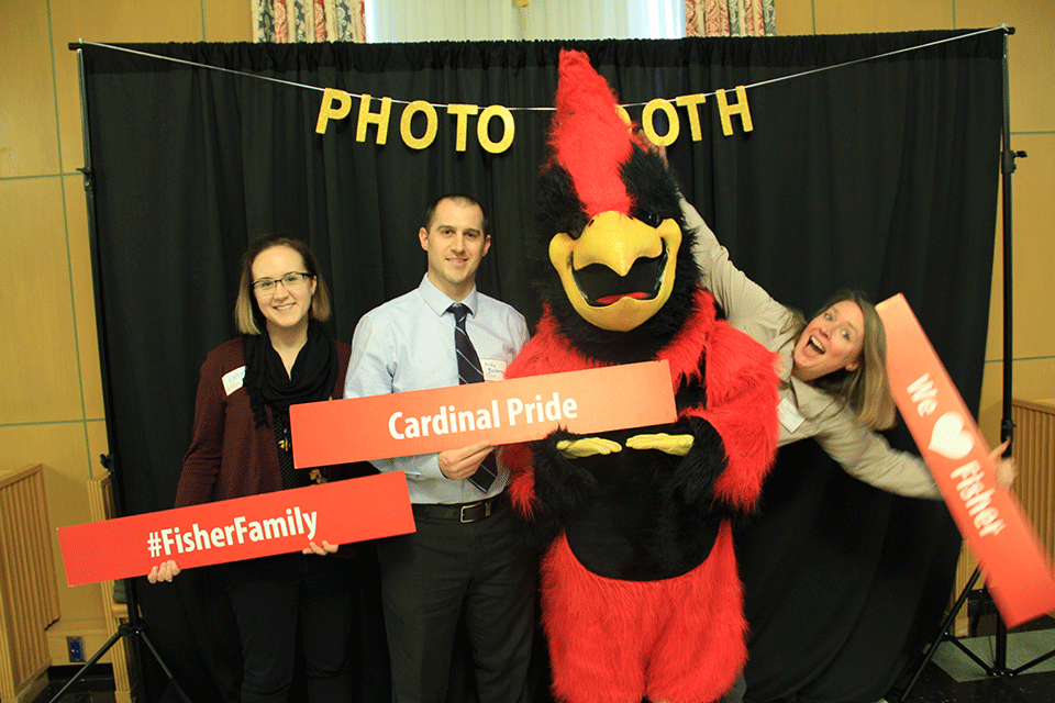 Employees and Cardinal, Fisher's mascot, hold signs showing their Fisher pride.