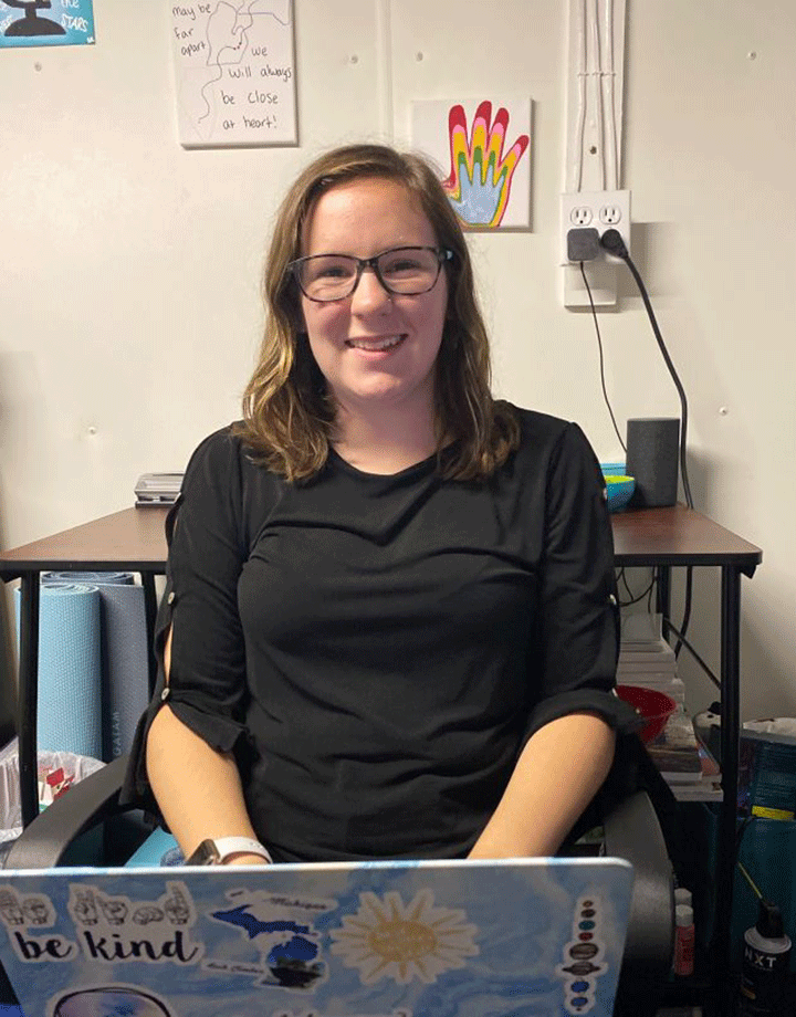 Emily Moore sits at a laptop in her room.