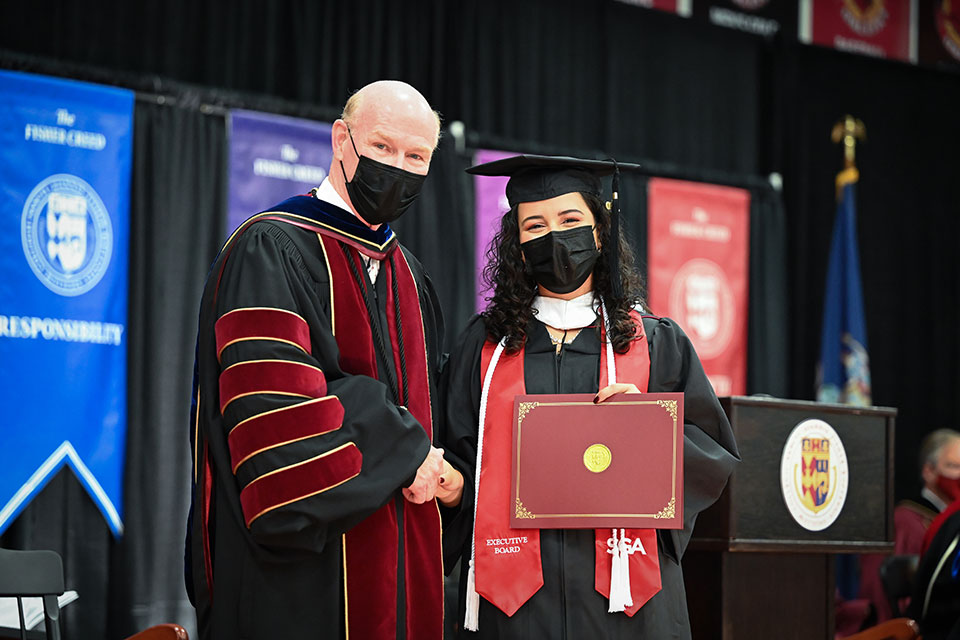 President Rooney congratulates a member of the Class of 2020.