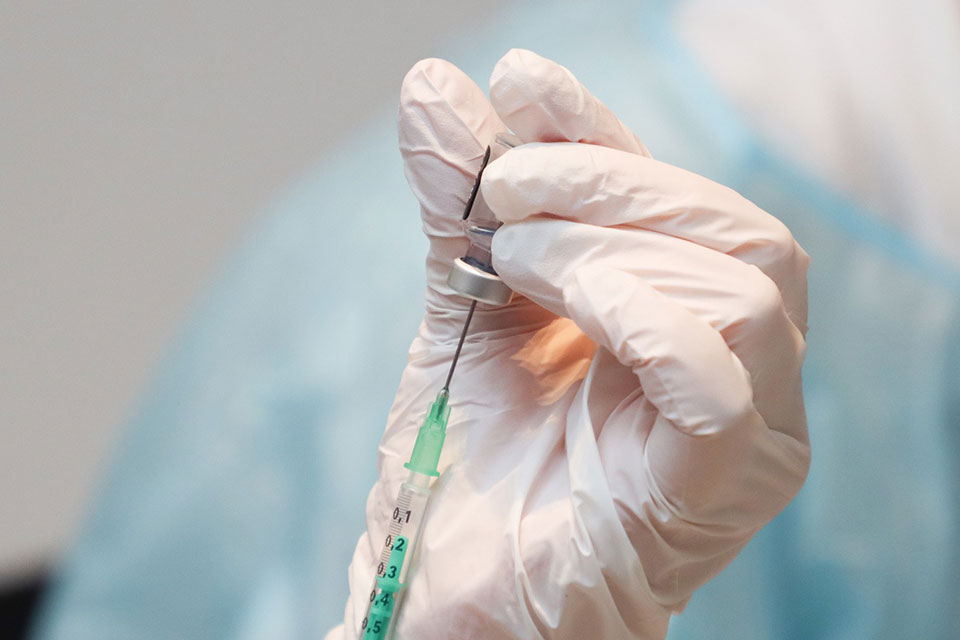 A nurse prepares a vaccine.