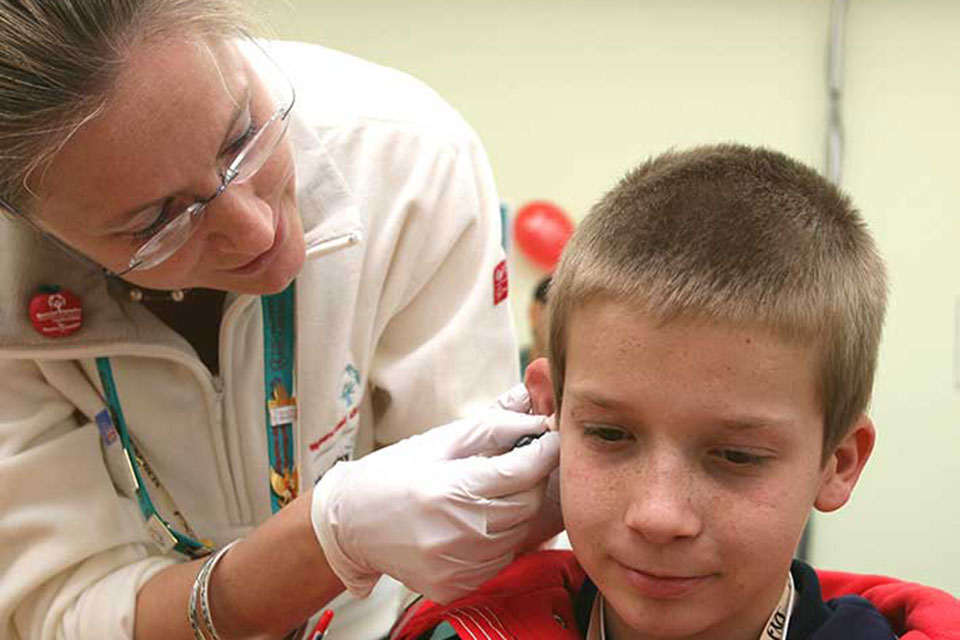 A nurse performs a check-up on a child.