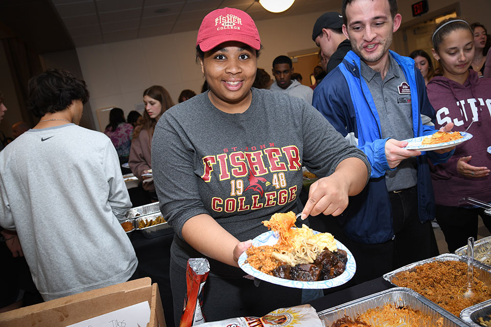 A student serves up an authentic meal during the annual Inclusion Dinner.