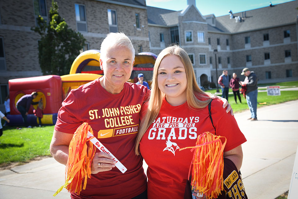 Two Fisher graduates at the Pre-game Carnival during Alumni Weekend.