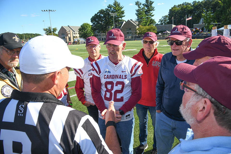 Members of the Class of 1972 toss the coin at the start of the football game during Alumni Weekend.