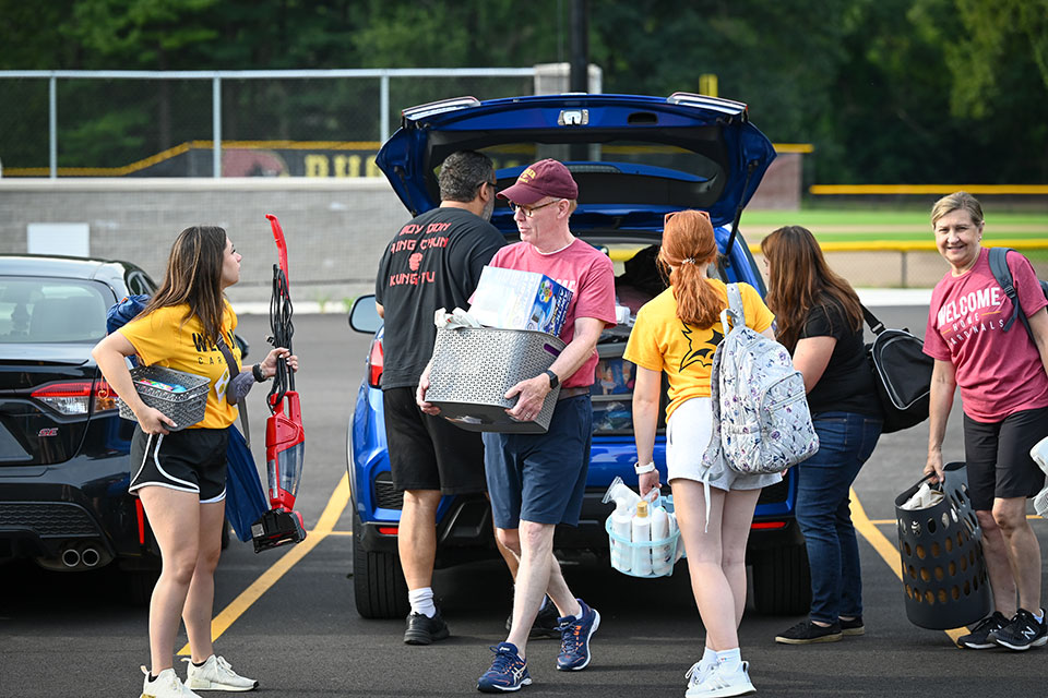 President and Mrs. Rooney help a first-year student move into Murphy Hall.