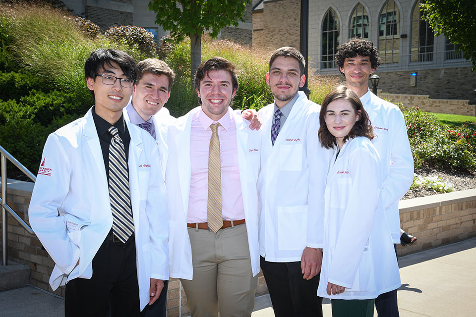 Students celebrate after receiving their white coats.