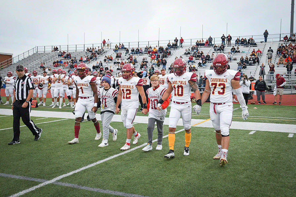 The Fisher football captains and honorary coaches walk to the 50-yard line for the coin toss during the 2022 Courage Bowl.