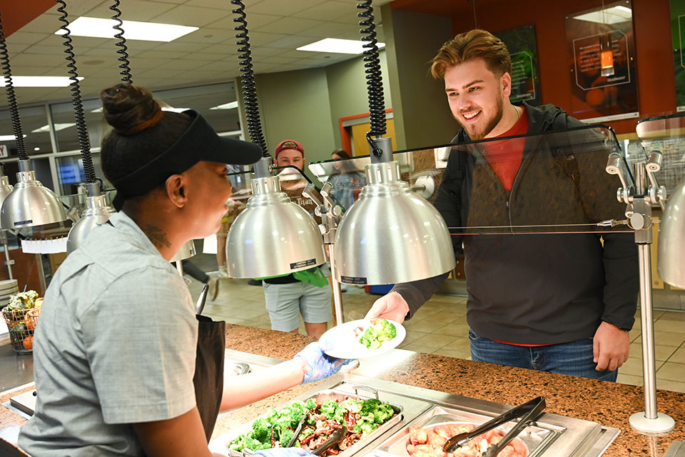 A student recieves a plate of food in the Ward-Haffey Dining Hall.