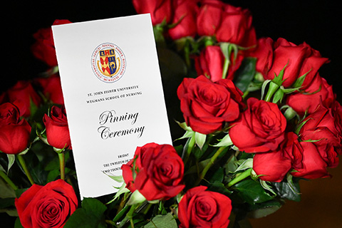 The nursing pinning ceremony program surrounded by roses.
