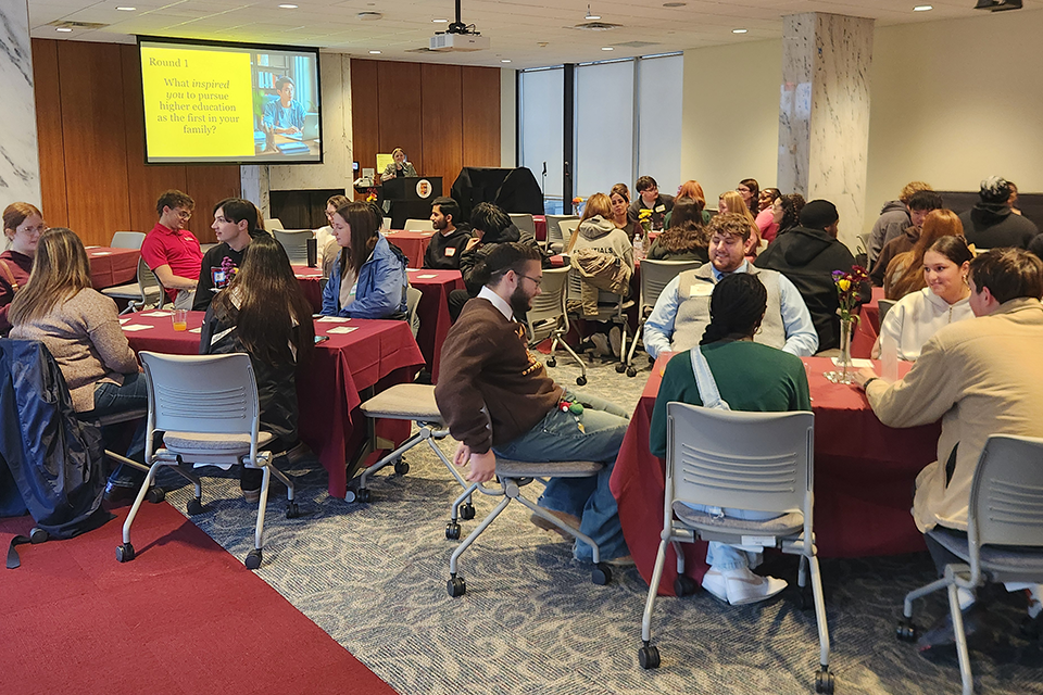 Students, employees, and alumni are seated at tables throughout the Elaine Wilson Formal Lounge.