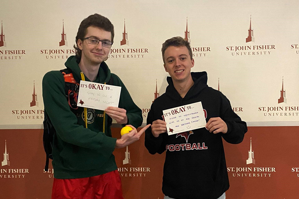 Students hold up signs promoting mental health wellness.