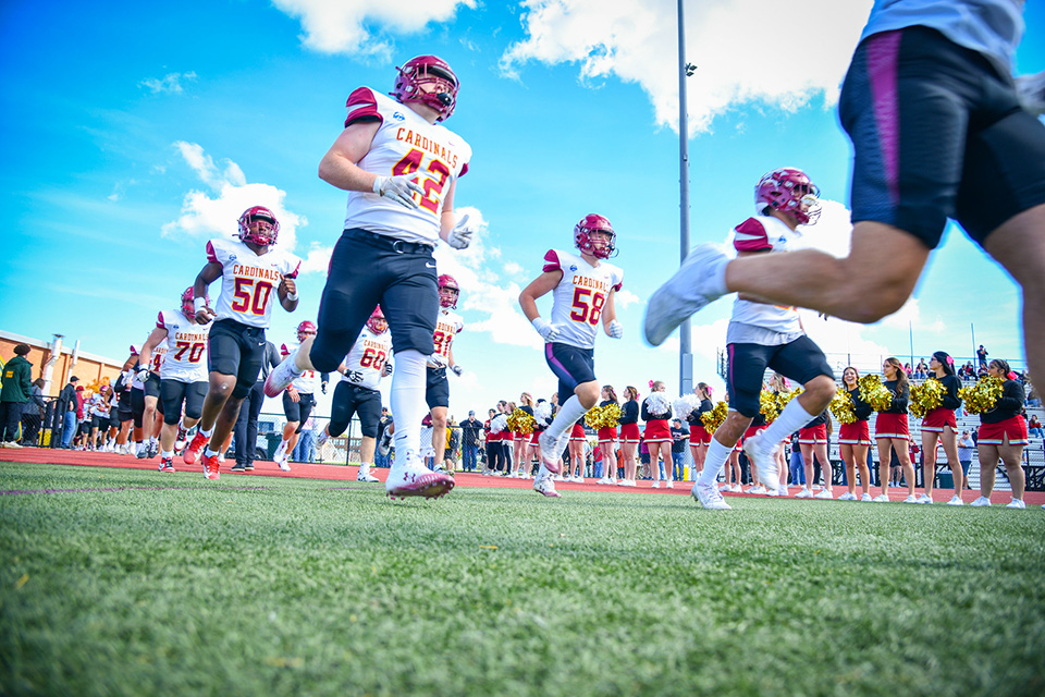Fisher Football team runs across the football field for the Courage Bowl.