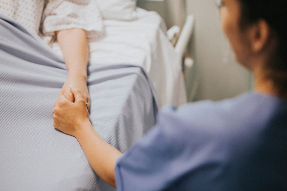 A nurse comforts a patient.