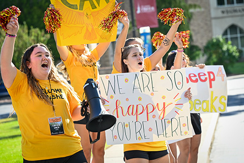 Orientation Team welcoming new students with signs.