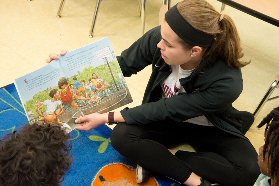 A Fisher student reads to children.