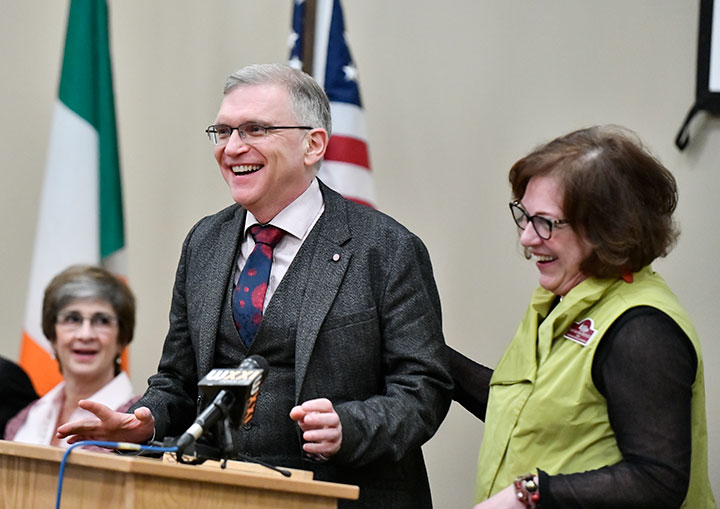 Dr. John Wells joins Dean Dianne Cooney Miner at the podium to offer remarks.