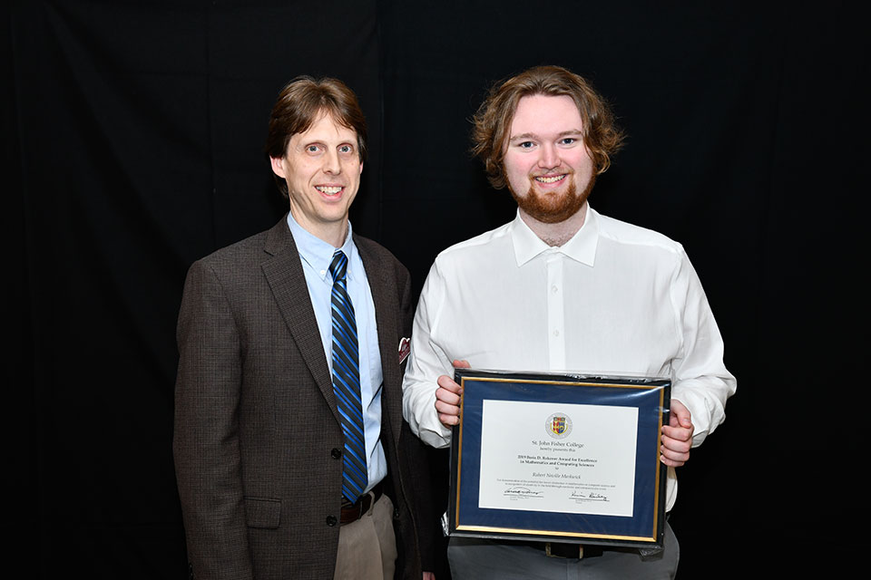 Dr. Kris Green presents an award to senior Robert Markwick.