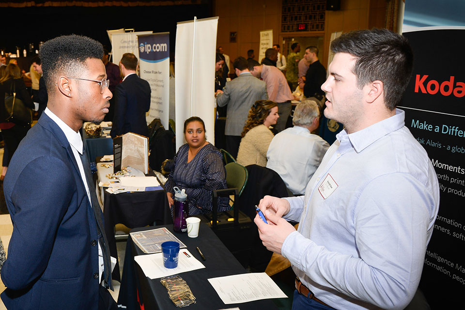A student talks with a potential employer at a career fair.