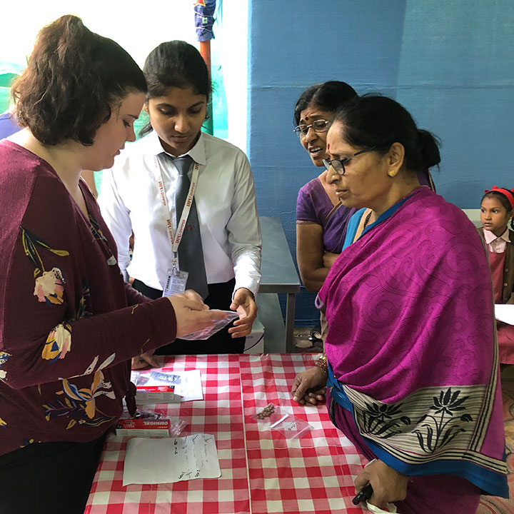 A student from the School of Pharmacy talks with a patient at the clinic.