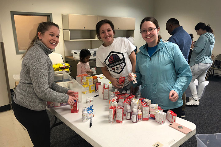 Students sort medication at a clinic.