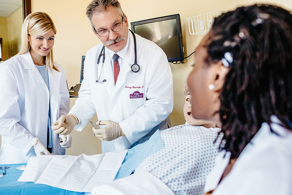 Two graduate nursing students talk with Dr. Henry Moscicki.