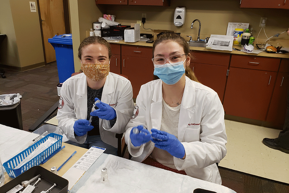 Two pharmacy students volunteer at the RRH COVID0-19 vaccine clinic.
