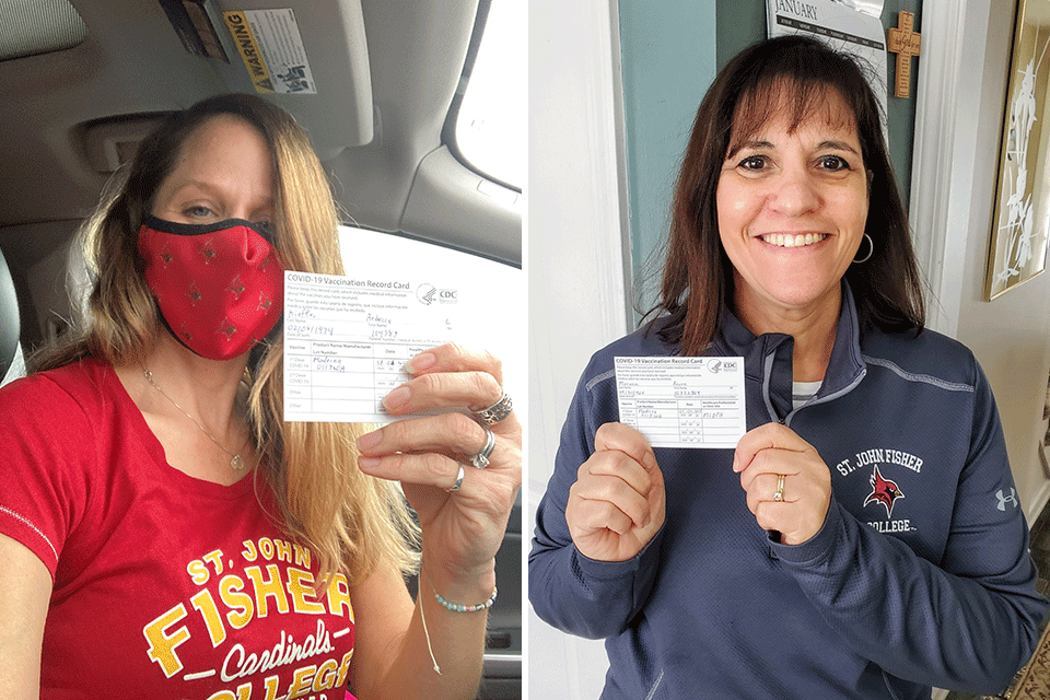 Two members of the Health and Wellness Staff hold up cards showing they received the COVID-19 vaccine.