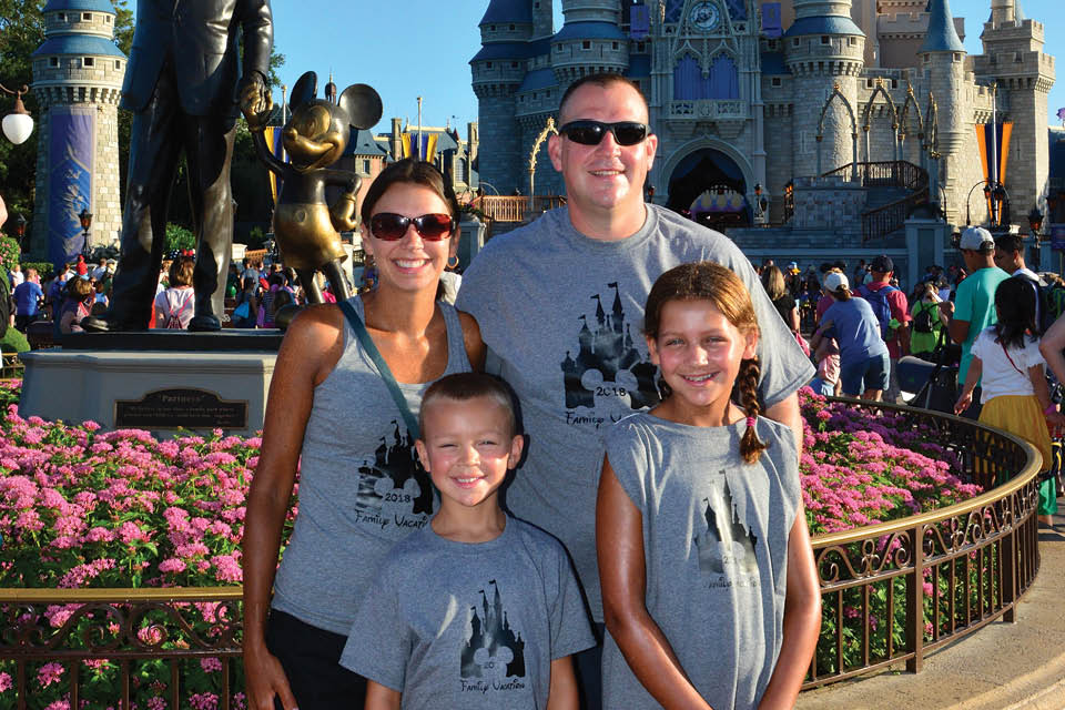 Dave Roberts standing with family at the Magic Kingdom