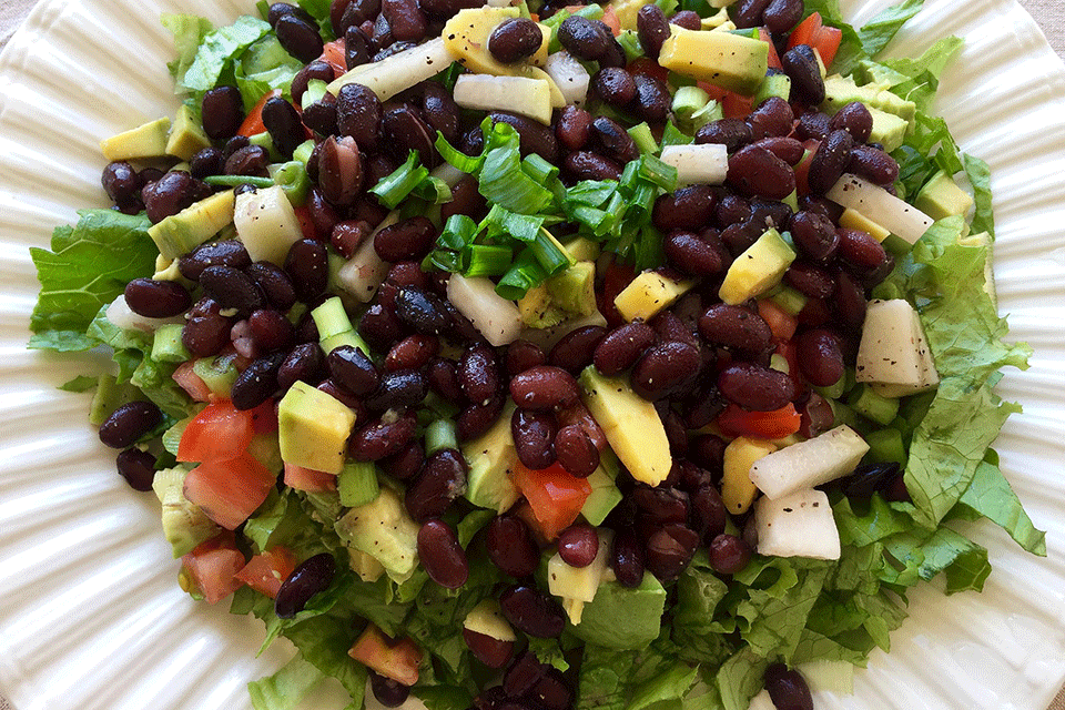 A salad full of vegetables and fruit.