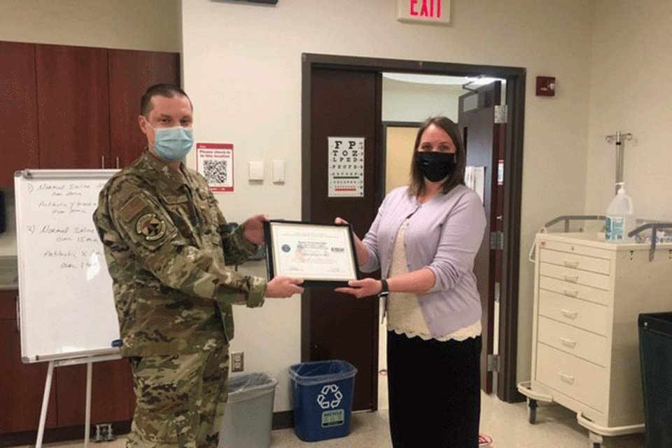 Adjunct faculty member Bryce Bishop presented Joanne Weinschreider with a certificate from the Office of the Secretary of Defense honoring her as a Patriotic Employer.