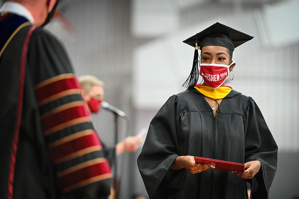 A graduate of the School of Nursing receives a diploma.